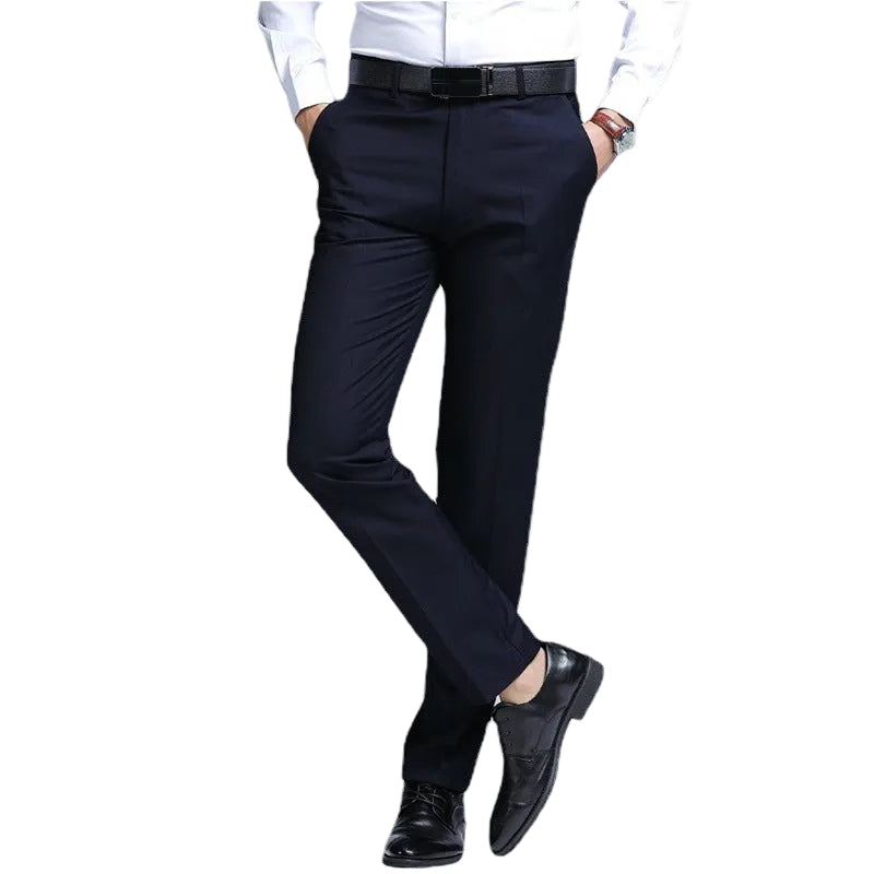 A man wearing dark navy blue dress pants, a white dress shirt, a black belt, and black dress shoes, shown from the waist down against a plain white background.