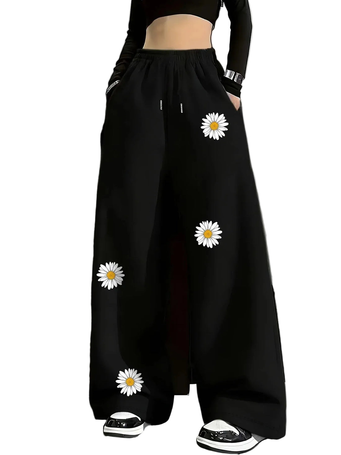 Black wide-leg pants with white daisy patterns worn by a person against a gray background