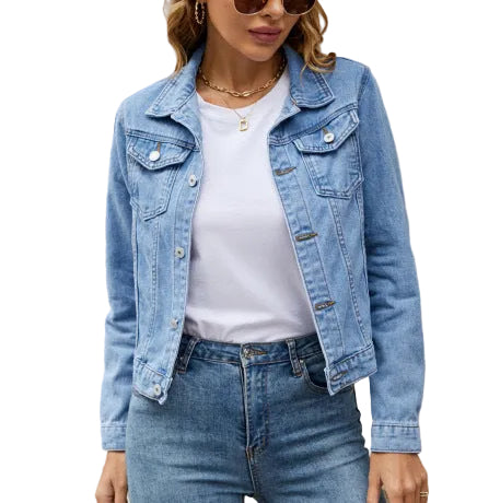 Person wearing a denim jacket and jeans standing in front of a building with text.