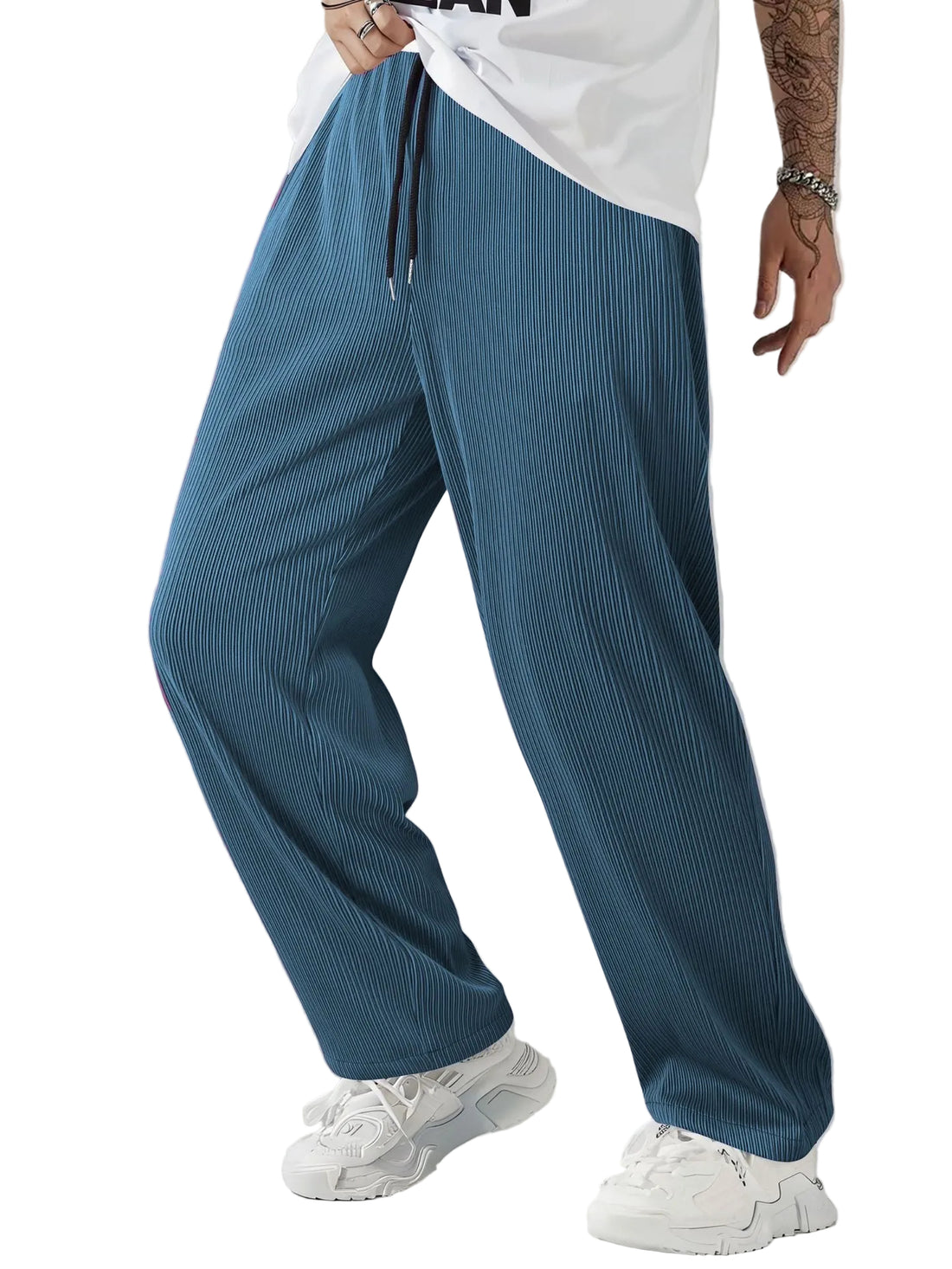 Person wearing blue corduroy pants and white sneakers on a plain background