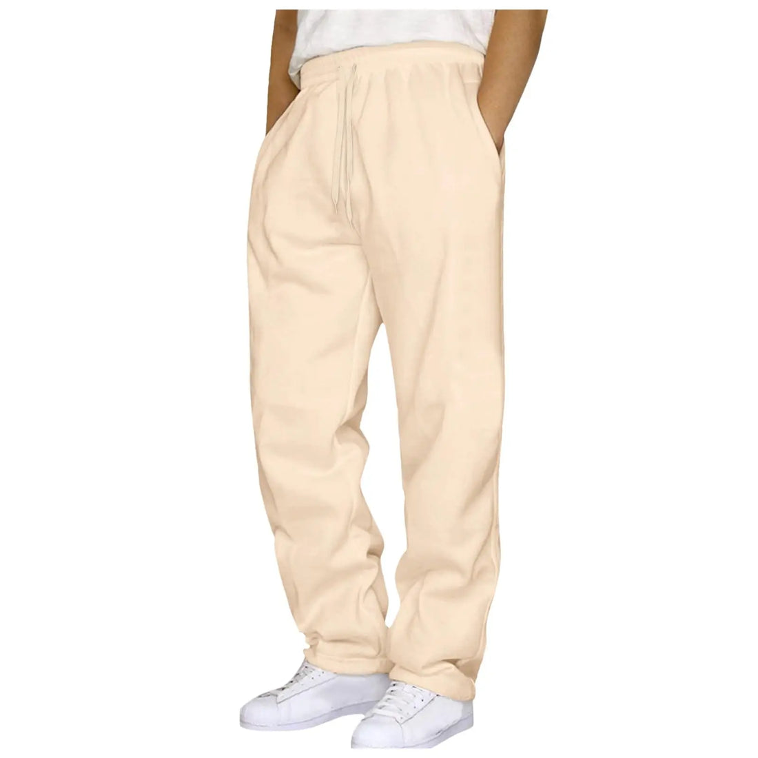 A person wearing loose beige drawstring sweatpants with side pockets and white sneakers, shown from the waist down on a plain white background.