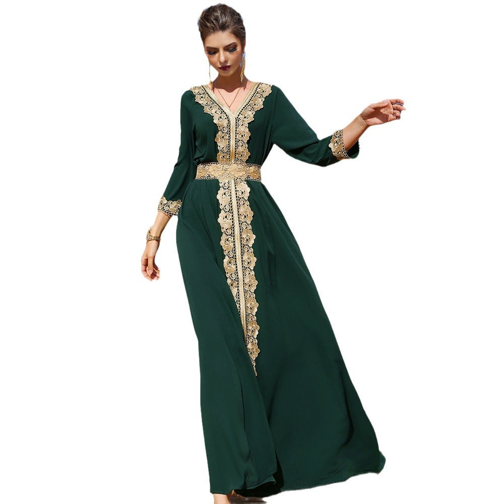 A woman modeling a dark green maxi dress with ornate gold lace embroidery along the V-neckline, sleeves, and center front panel, set against a plain white background.