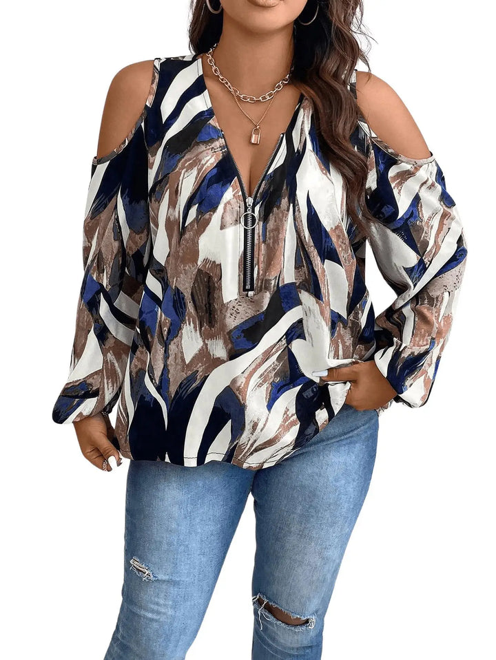 Woman wearing a patterned blouse with long sleeves and ripped jeans on a white background