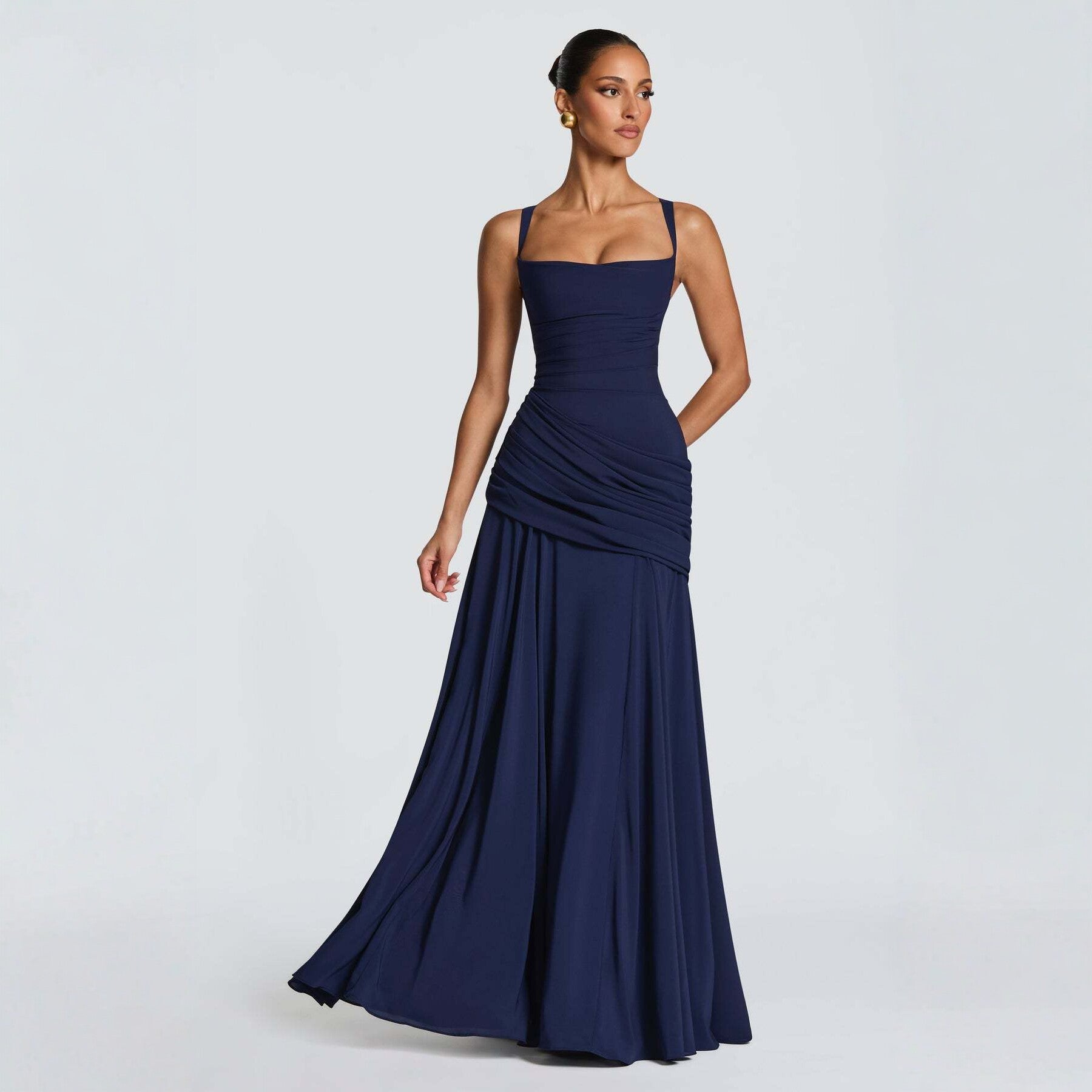 Woman wearing a navy blue evening gown on a light gray background