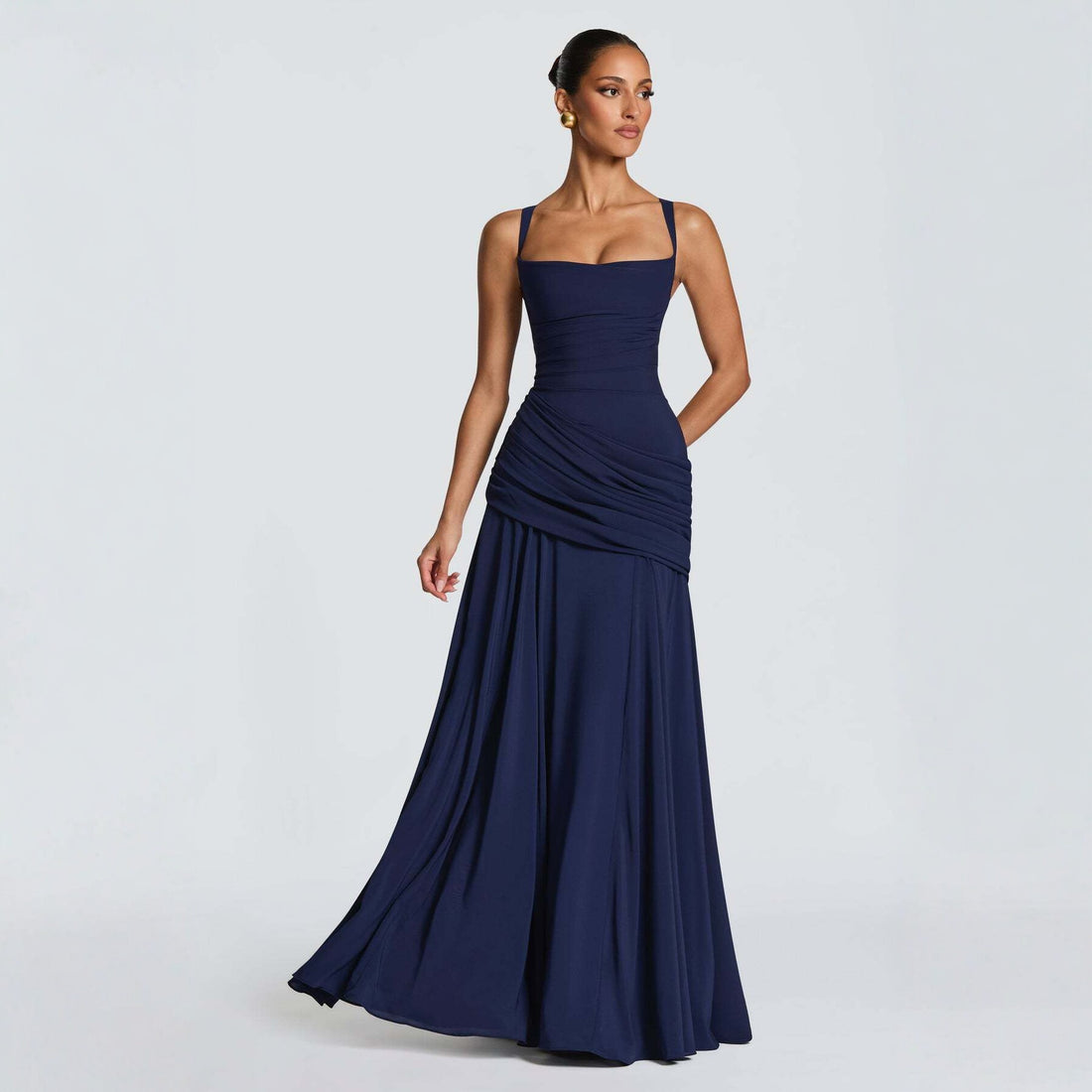 Woman wearing a navy blue evening gown on a light gray background