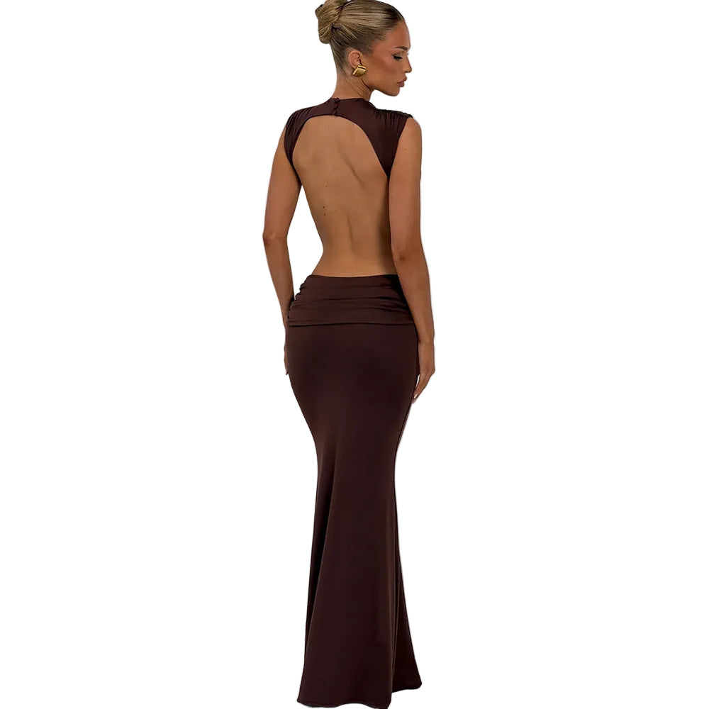 Woman wearing a brown evening gown with an open back against a plain background