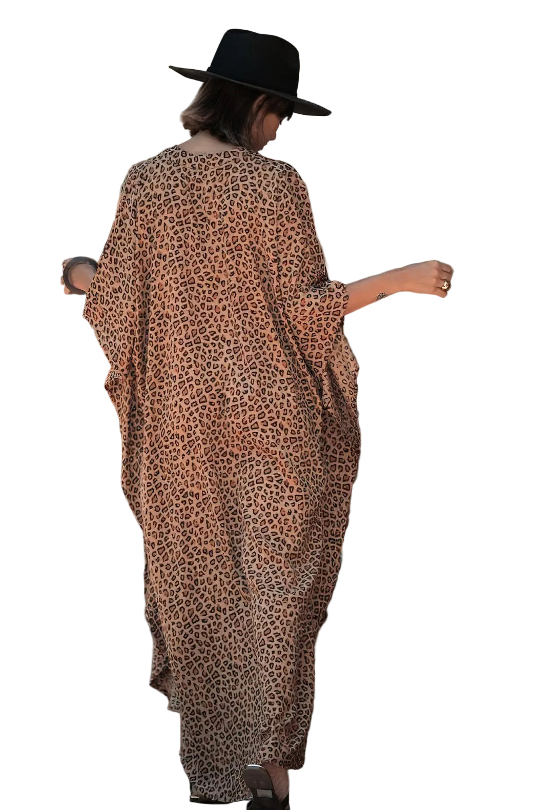 Person wearing a leopard print dress and black hat walking on a street.