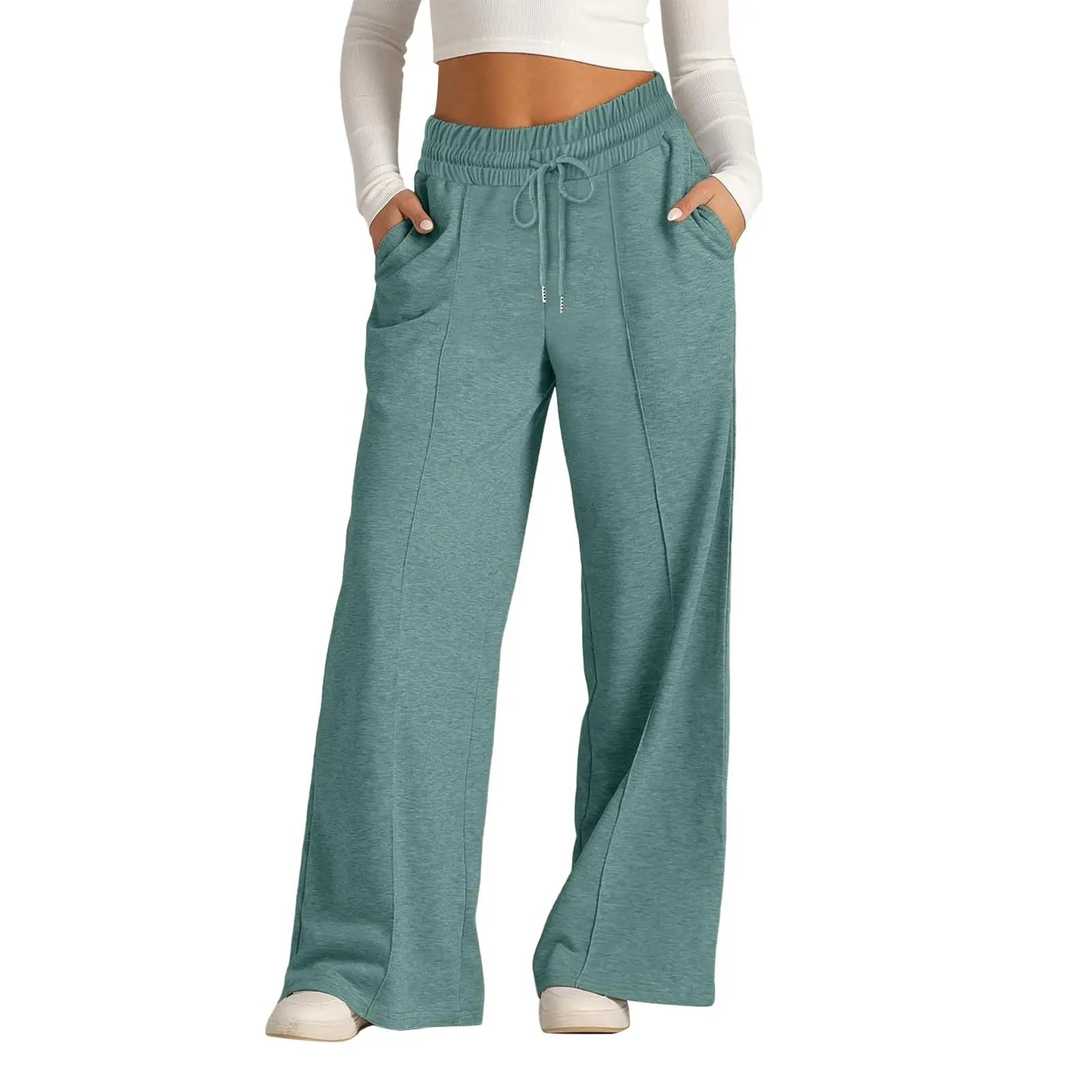 Teal sweatpants worn by a person on a white background