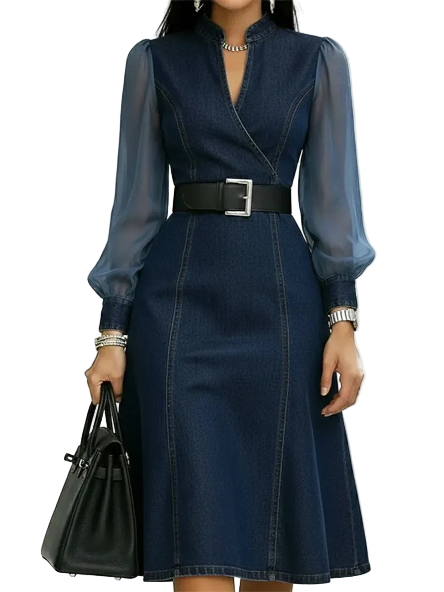Woman wearing a blue denim dress with sheer long sleeves on a white background