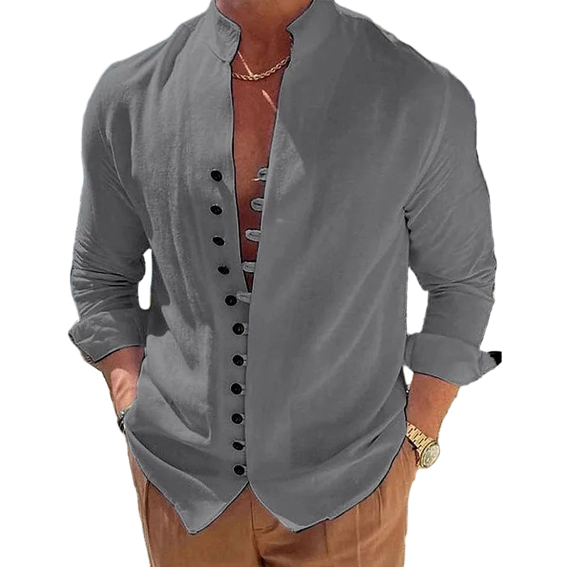 Man wearing a gray button-up shirt with a blurred outdoor background