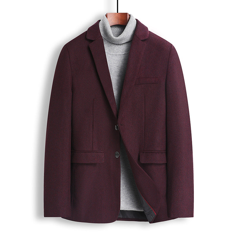 A men's blazer in deep burgundy, styled over a gray turtleneck sweater and hanging on a wooden hanger against a plain white background.