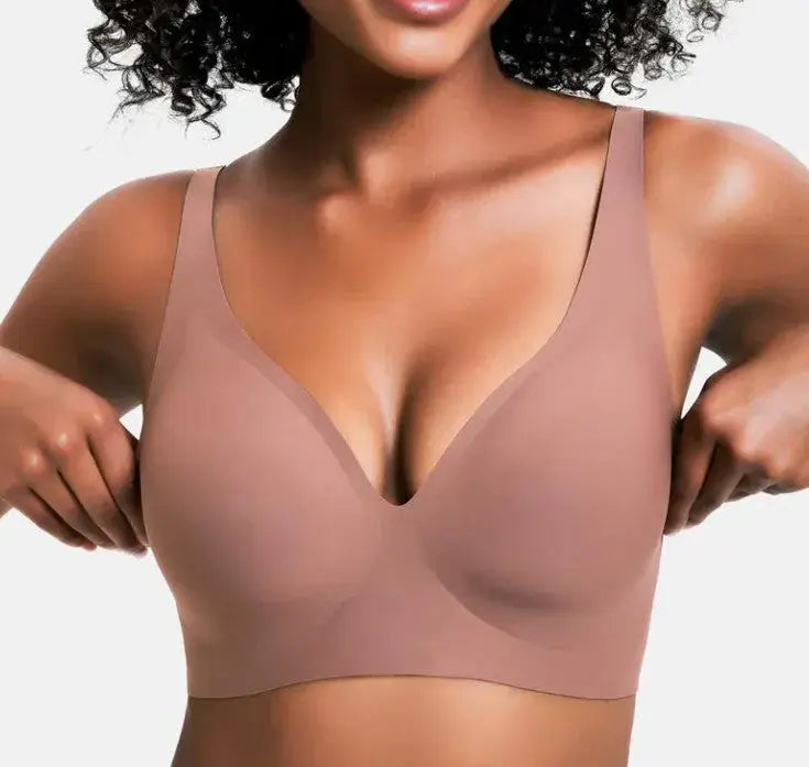 Woman wearing a beige bra against a plain background