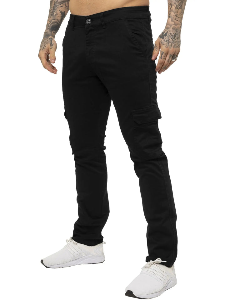 Person wearing black cargo pants and white sneakers on a white background
