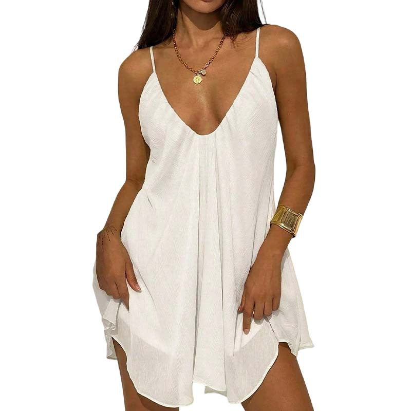 A woman wearing a white sleeveless mini dress with thin straps and a deep V-neckline, shown against a plain white background.