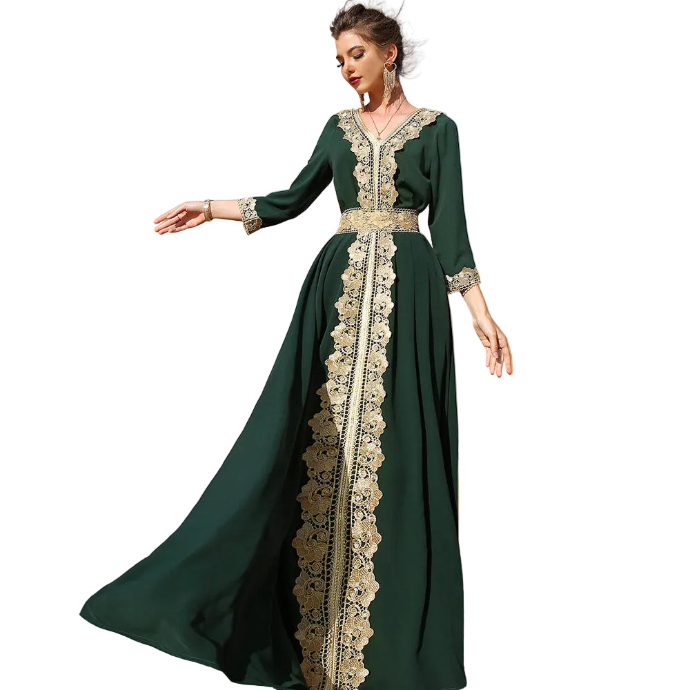 Woman in a green dress with gold lace details standing in a desert landscape.