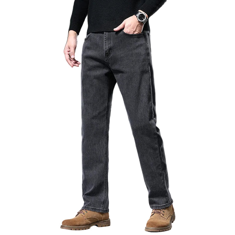 Person wearing gray jeans and brown boots on a gray background