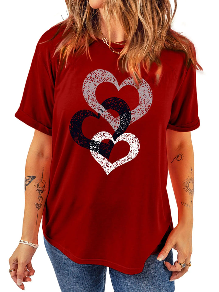 Red t-shirt with heart design worn by a person on a white background