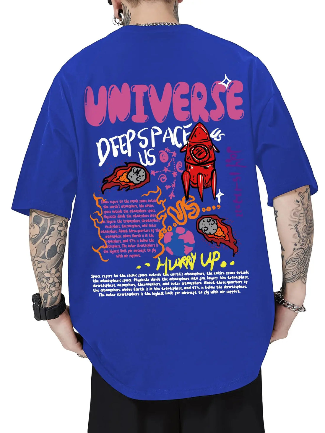 A person shown from the back wearing an oversized royal blue graphic T-shirt with large pink, white, red, and orange space-themed artwork and text reading 'UNIVERSE DEEP SPACE US' and 'HURRY UP.' The background is plain white.