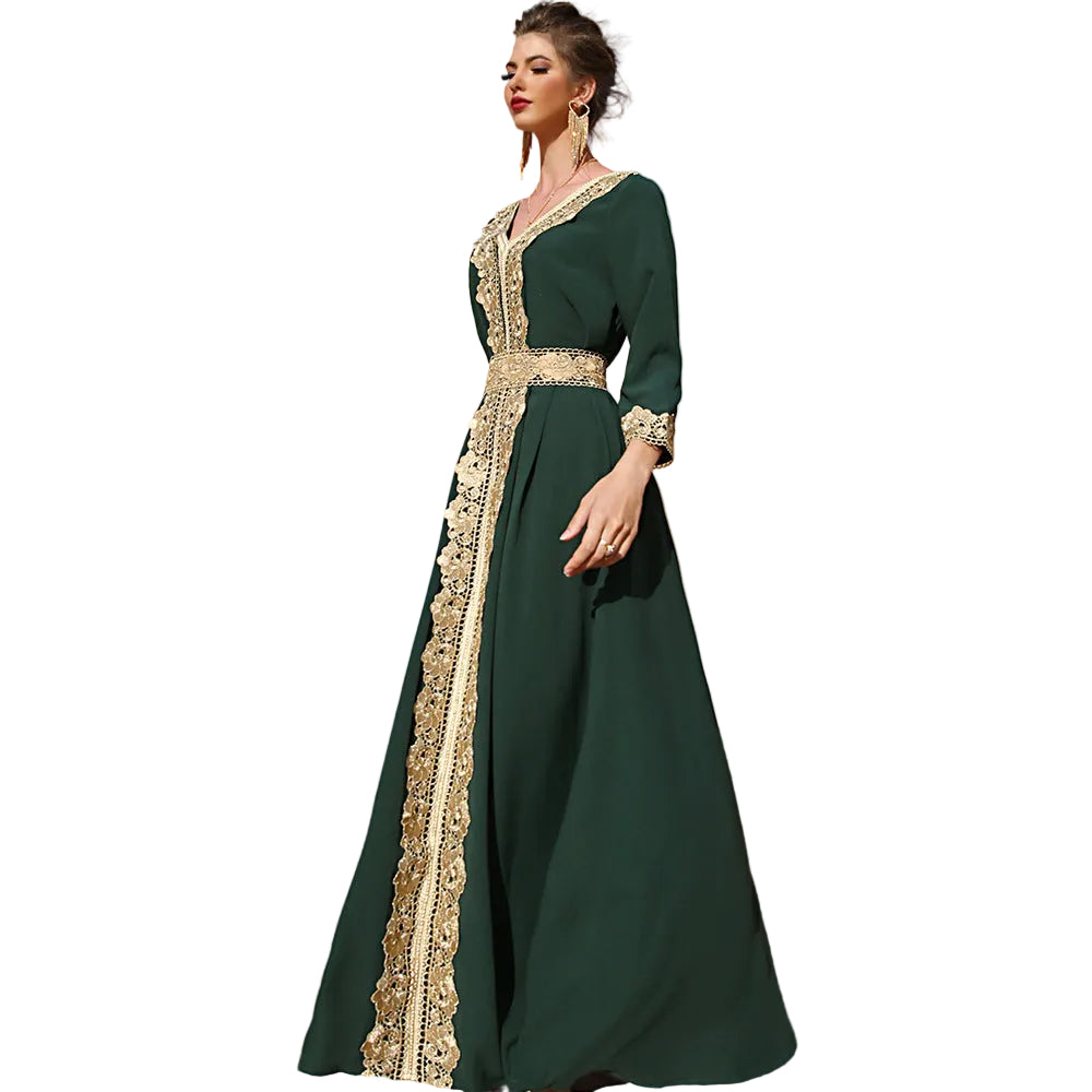 Woman in a green dress with gold embroidery standing in a desert landscape