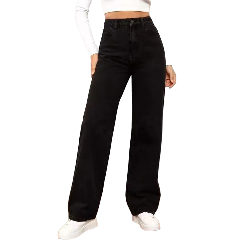 Person wearing black wide-leg jeans and white shoes in a minimal indoor setting
