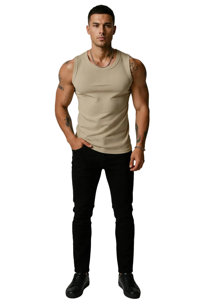 Man wearing a beige tank top with tattoos on arms against a plain background