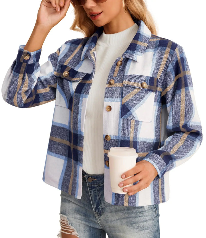 Person wearing a blue and white plaid jacket holding a coffee cup on a white background
