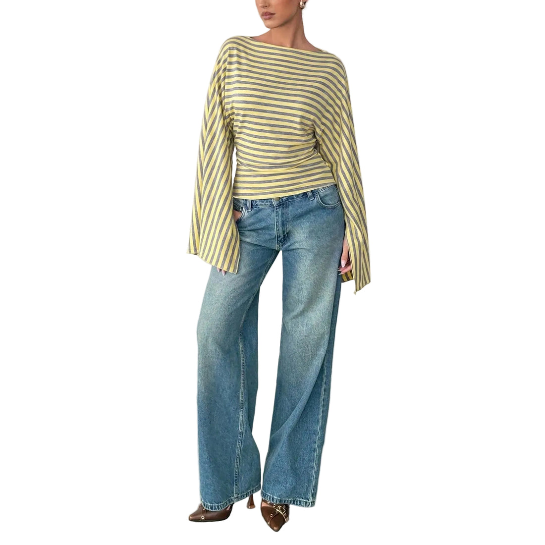 A model wearing a yellow and green striped long-sleeve top with wide bell sleeves, paired with wide-leg blue jeans and brown pointed-toe heels, standing against a neutral studio background.