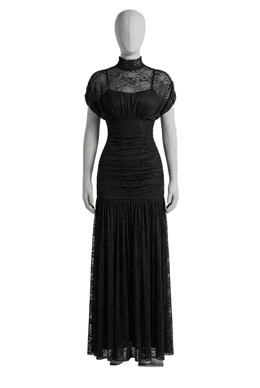 A woman takes a mirror selfie wearing a black lace and mesh maxi dress with short sleeves, holding a gold clutch purse in front of a wooden door.