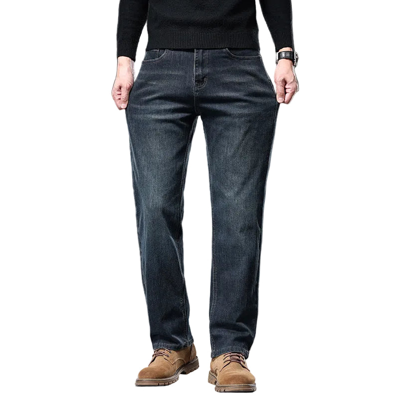 Person wearing blue jeans and brown shoes on a dark background