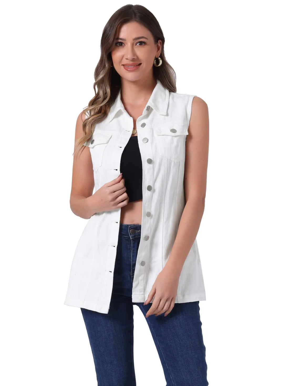 A woman modeling a sleeveless white denim-style vest over a black crop top and blue jeans, photographed against a plain white studio background.