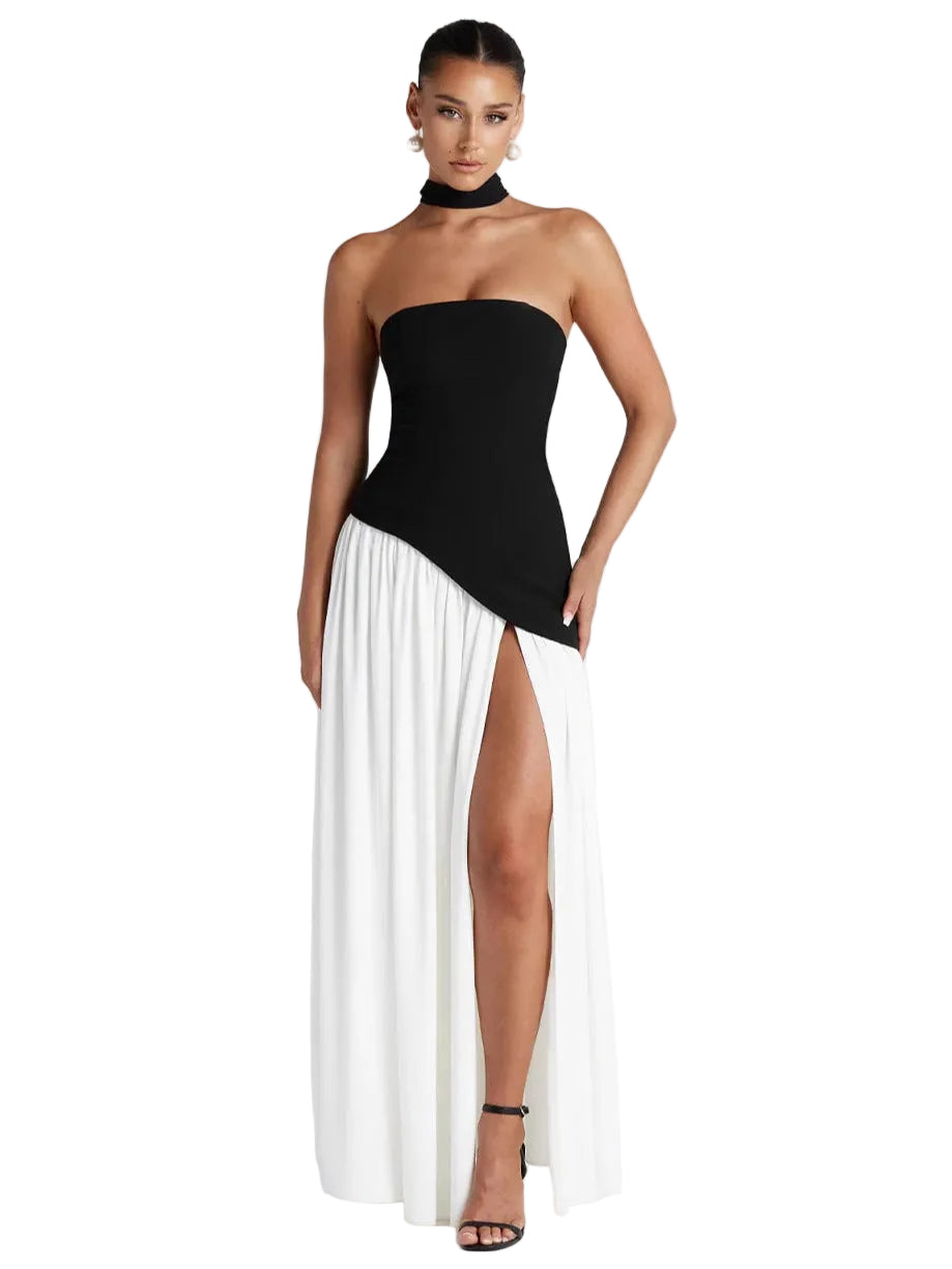 Woman wearing a black and white dress with a high slit on a white background