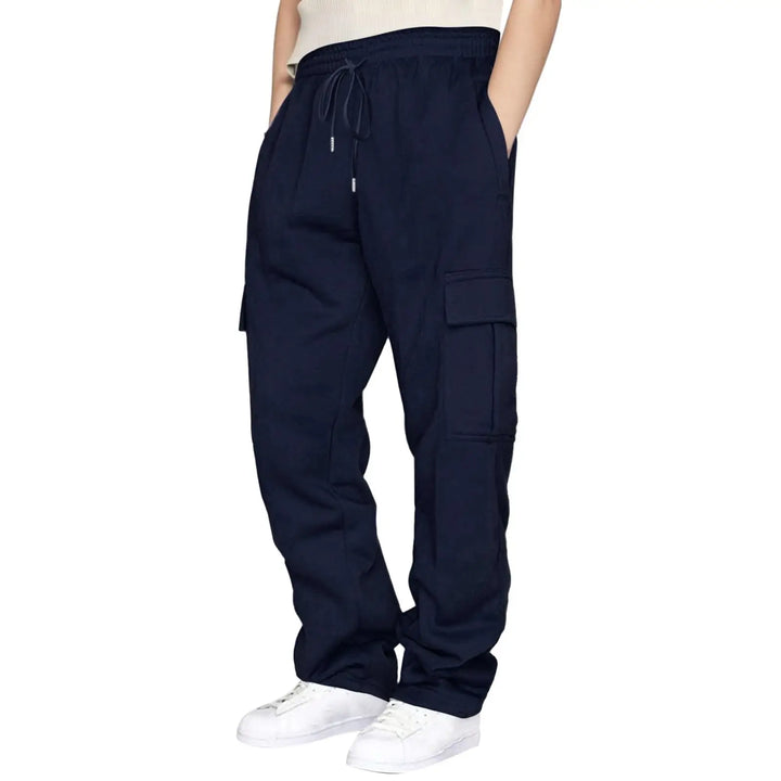 A person wearing dark navy cargo sweatpants with a drawstring waist, shown from the waist down against a plain white background.