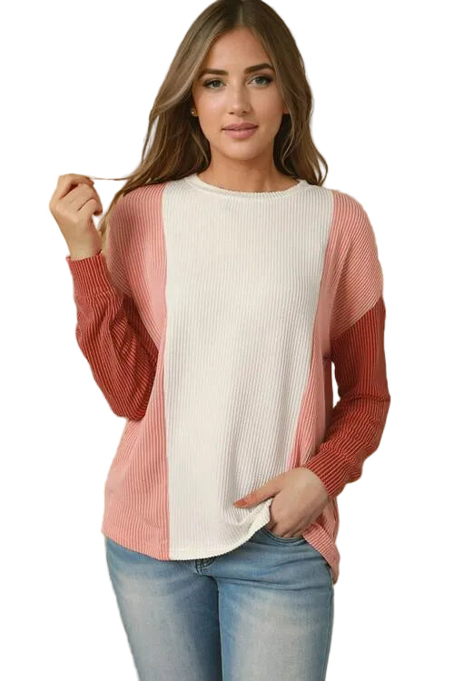 Woman wearing a pink and white long-sleeve top with a blurred background