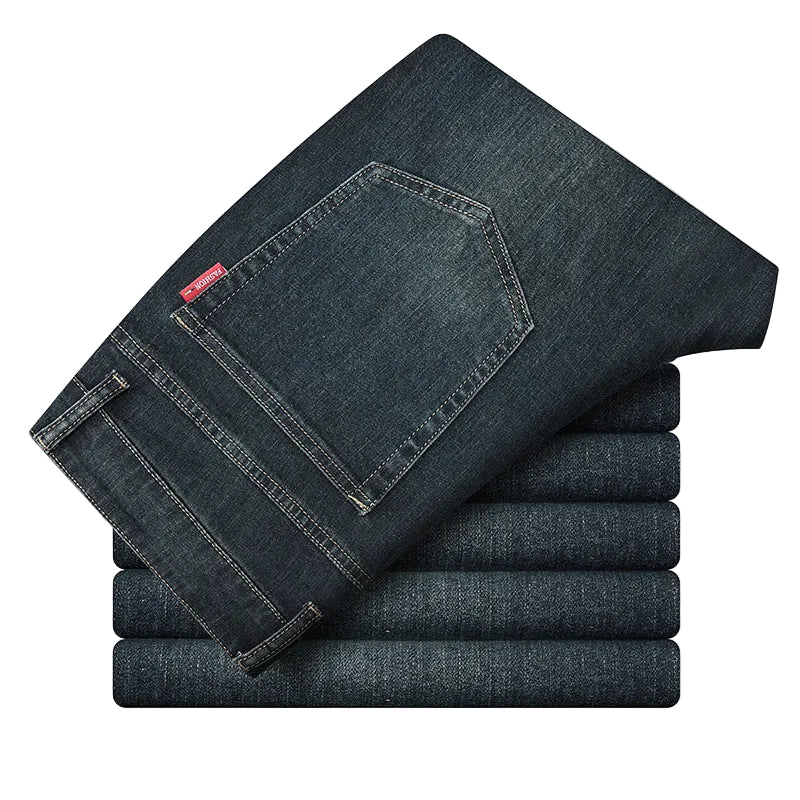 Stack of folded dark blue jeans on a white background