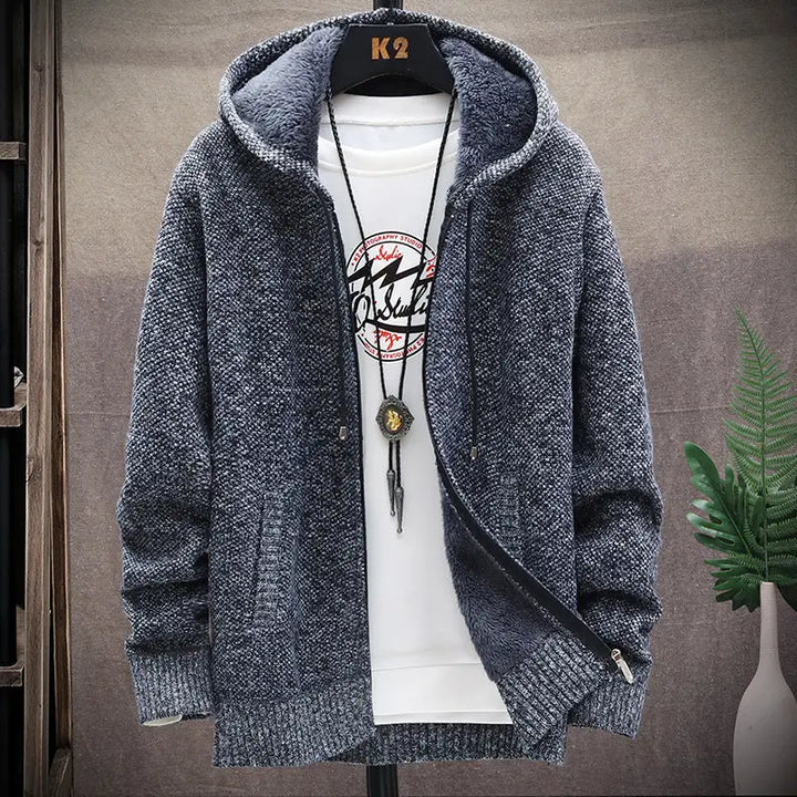 Blue knitted hoodie on a mannequin with a white shirt underneath, against a neutral background.