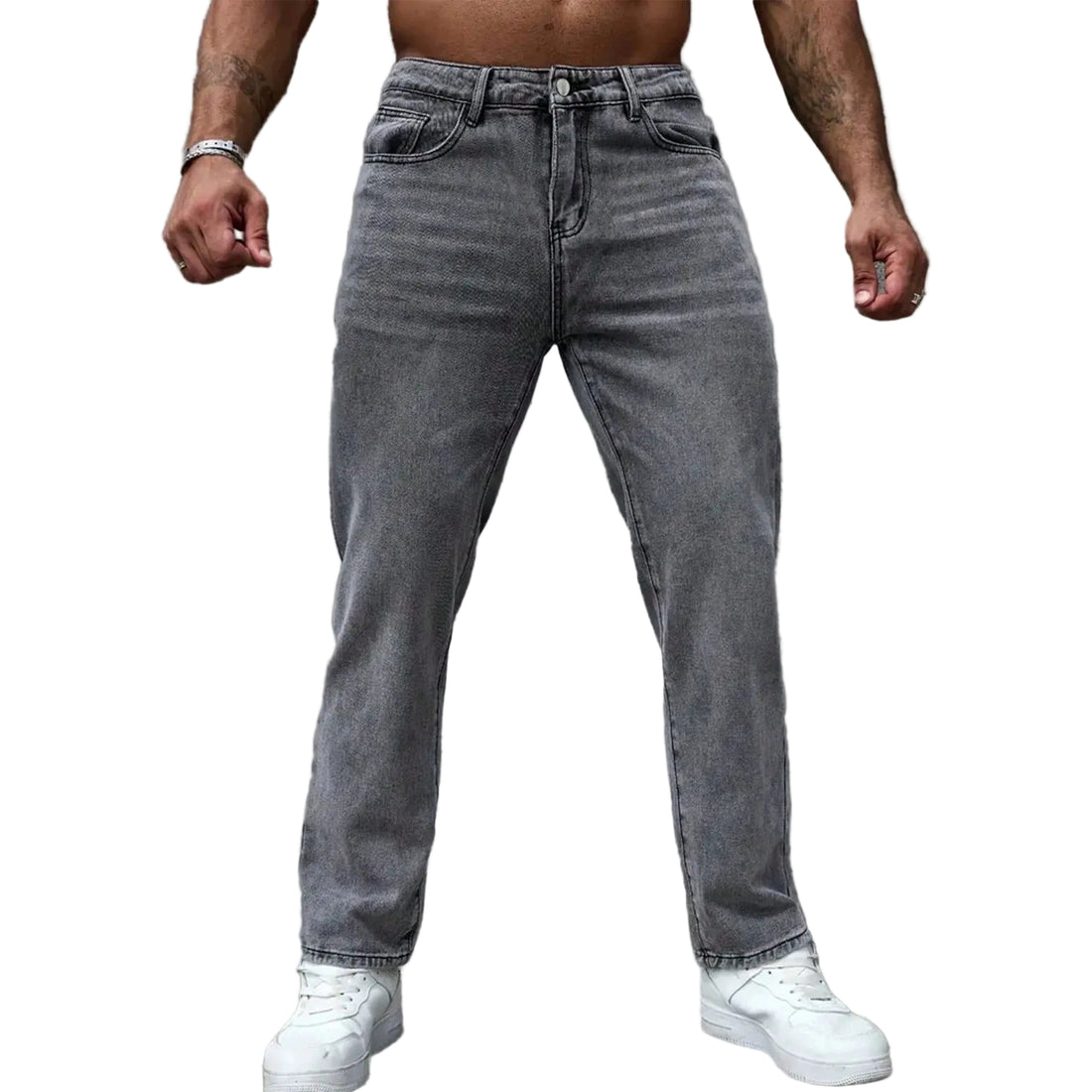 A man wearing gray washed denim jeans and white sneakers, shown from the waist down against a textured gray wall.