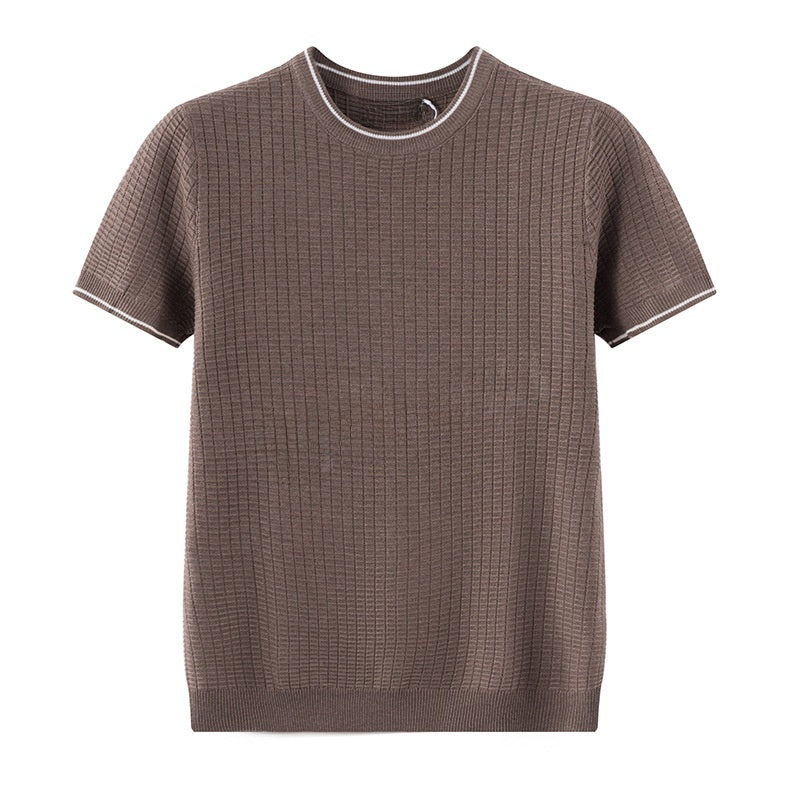 A black Nike short-sleeve scoop-neck t-shirt featuring a retro-style graphic on the front that reads 'RUNNING ON CAFFEINE AND LOW EXPECTATIONS' in orange, yellow, and white text, with a small coffee mug illustration. A white Nike swoosh is visible on the left sleeve.