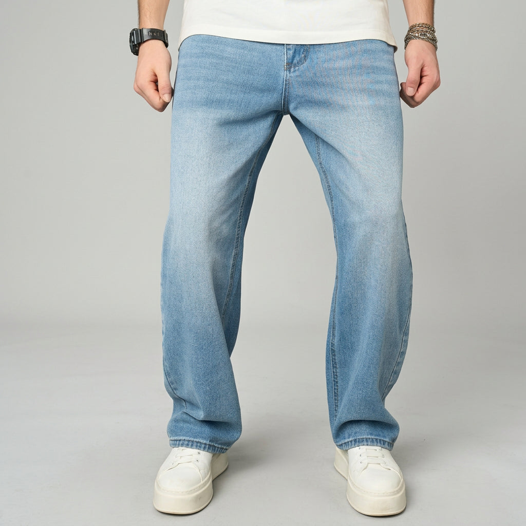Person wearing blue jeans and white sneakers on a gray background
