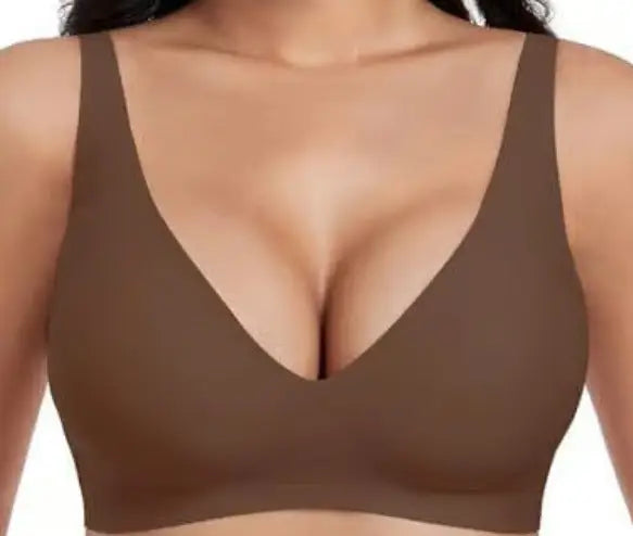 A close-up of a woman wearing a solid brown, deep V-neck bralette against a plain white background.