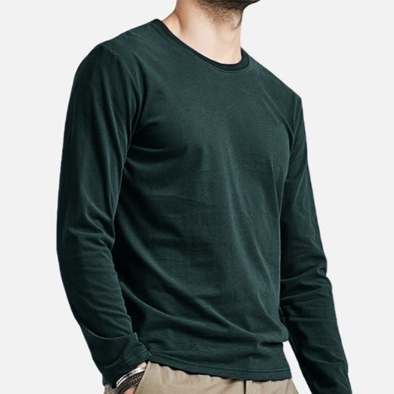 A man wearing a dark forest green long-sleeve crewneck shirt, cropped from the chin down, against a light gray background.