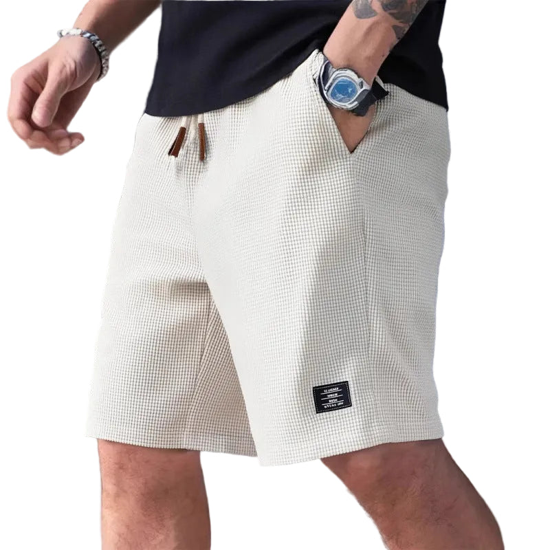 Person wearing white checkered shorts with a blurred background