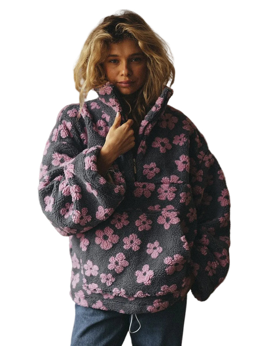 Person wearing a dark floral patterned sweater against a plain background