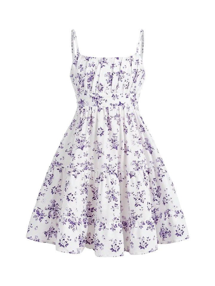 A white sleeveless mini dress with a purple floral print, featuring thin spaghetti straps, a smocked bodice, and a flared skirt.