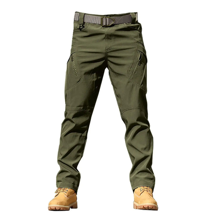 Green tactical pants with a belt and tan boots on a white background