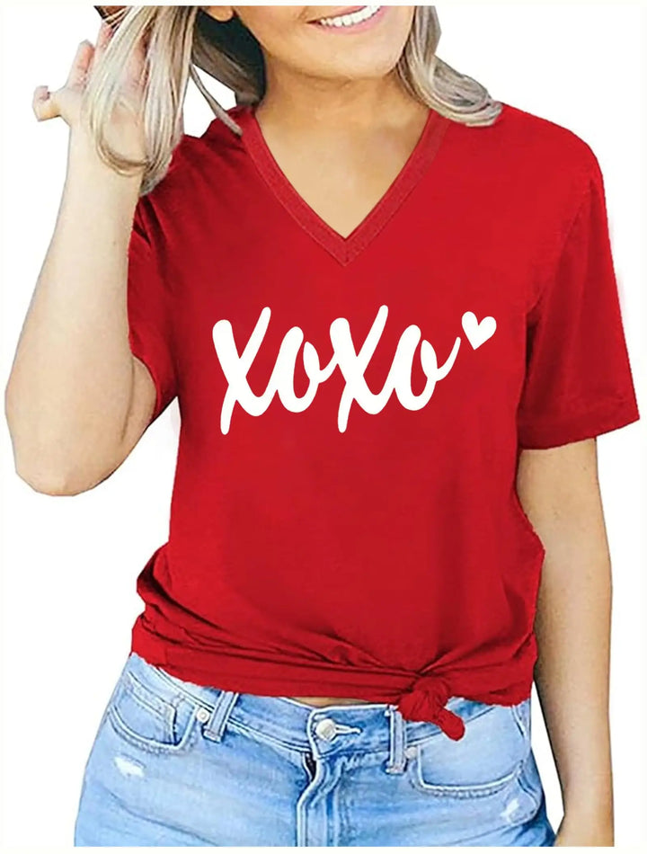 A woman wearing a red V-neck t-shirt with 'Xoxo' and a small heart printed in white across the chest, styled with light blue jeans.