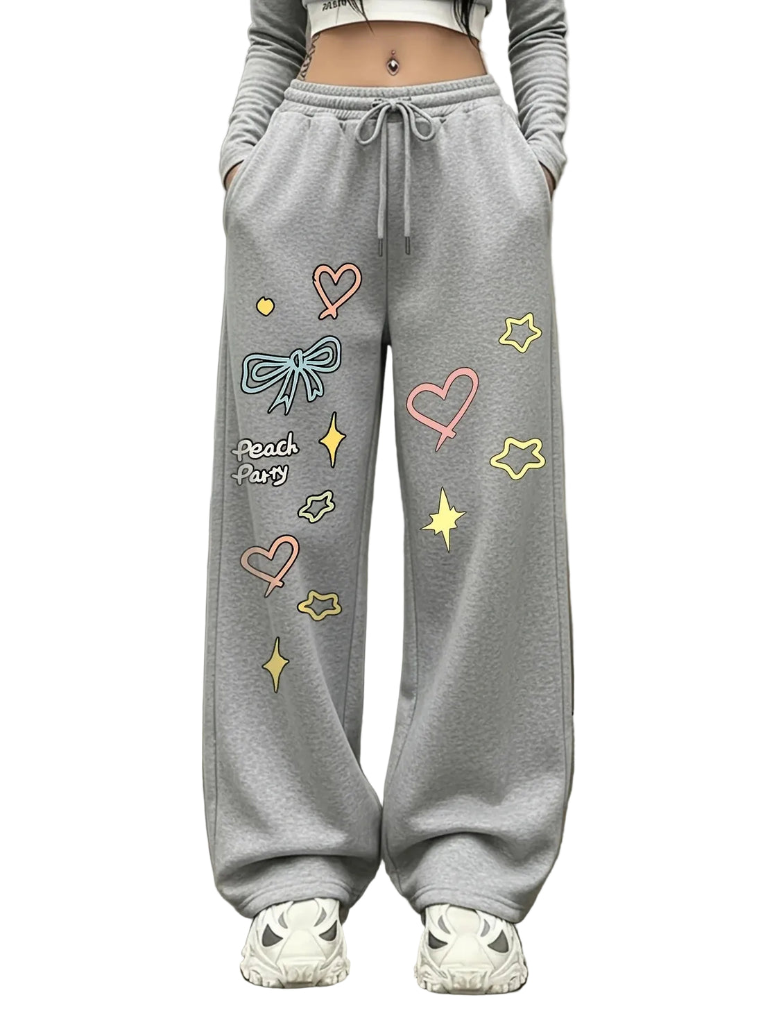 A person wearing light gray wide-leg sweatpants with colorful embroidered hearts, bows, stars, and the text 'Peach + Us' on the left leg, paired with white sneakers.