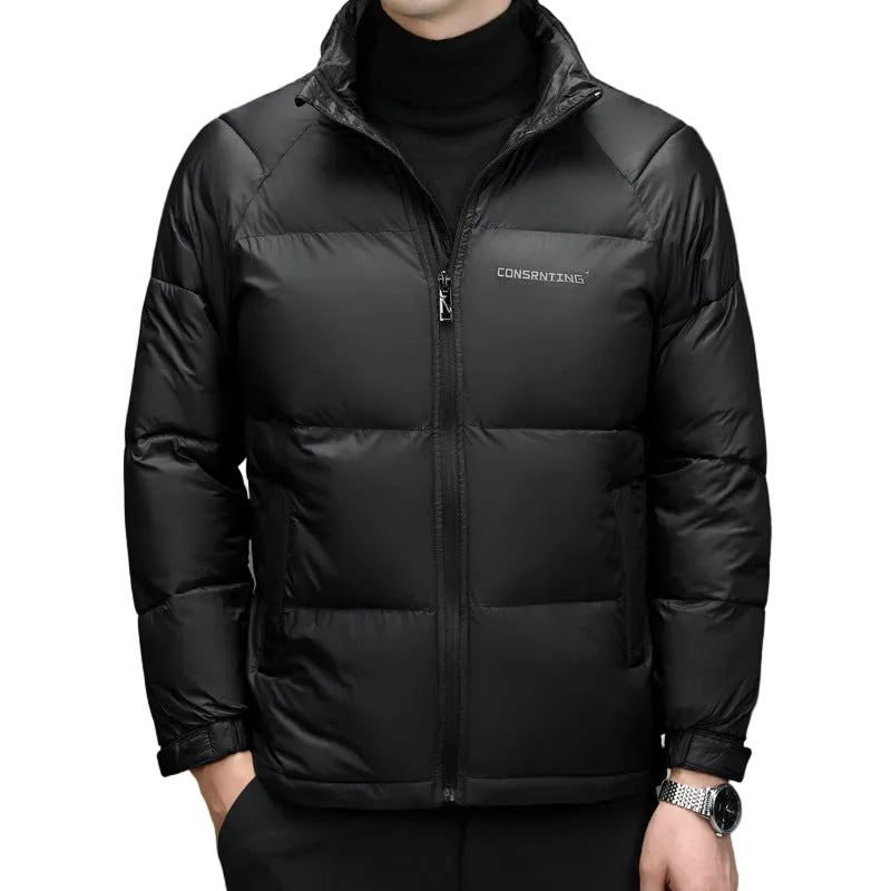 A man wearing a black puffer jacket over a black turtleneck sweater. The jacket features horizontal quilting, a full-length front zipper, a high collar, and a small white 'CONVERSING' logo on the left chest.