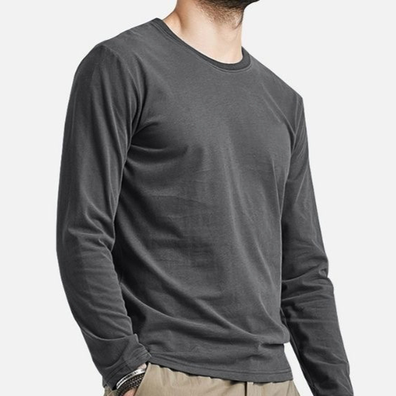 A man wearing a dark charcoal gray long-sleeve crewneck t-shirt, paired with khaki pants, shown from the neck down against a light gray background.
