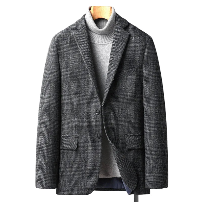 A men's gray and black checkered blazer jacket styled over a light gray turtleneck sweater, hanging on a wooden hanger against a solid gray background.