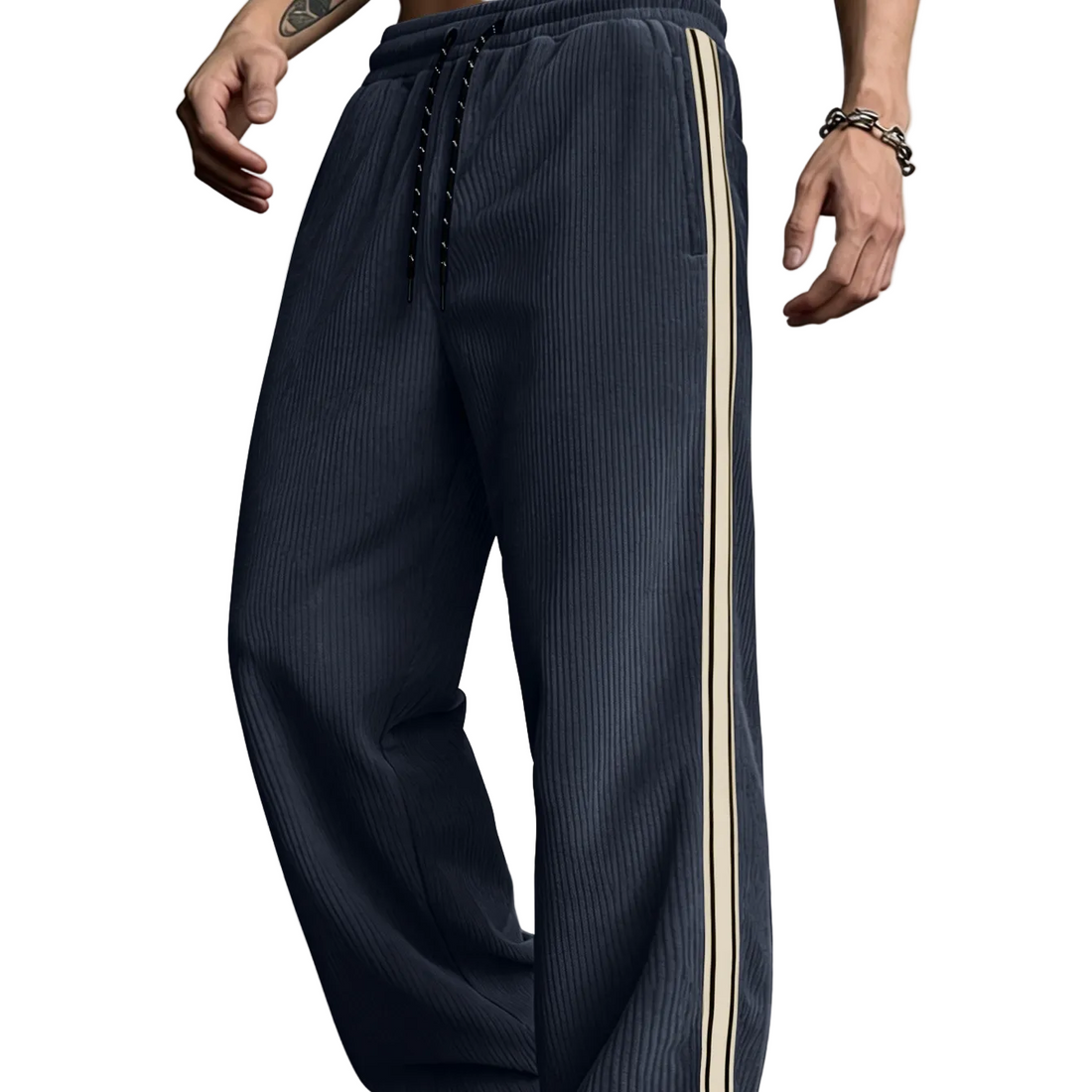 A person wearing dark navy ribbed drawstring sweatpants with a beige side stripe, shown from the waist down against a plain light gray wall.